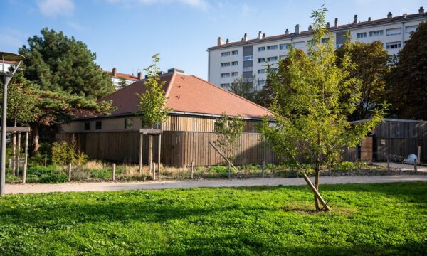 Parc végétalisé, arbres et pelouses verdoyantes, bâtiment en bois